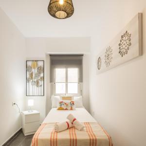 ein weißes Schlafzimmer mit einem Bett und einem Fenster in der Unterkunft Macflats Ciudad de las Ciencias in Valencia