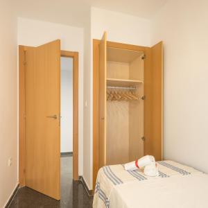 a small bedroom with a bed and a closet at Macflats Ciudad de las Ciencias in Valencia