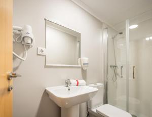 a white bathroom with a sink and a shower at Macflats Ciudad de las Ciencias in Valencia