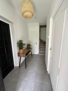 a hallway with a table and a potted plant at Suite Chic Lovhotêl in Persan