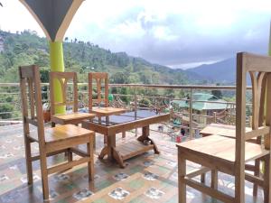 a group of wooden chairs and tables on a balcony at The Tea Garden Homestay by StayApart in Mangpu