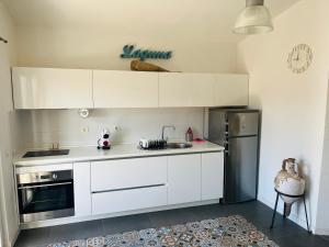 a kitchen with white cabinets and a stainless steel refrigerator at Apartment Laguna in Vinišće