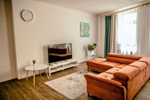 ein Wohnzimmer mit einem Sofa und einem TV in der Unterkunft Luxusní apartmán na Velkém náměstí in Hradec Králové