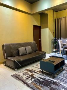 a living room with a leather couch and a coffee table at Dar Al Kahfi - Plaza Temerloh in Temerloh