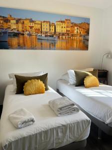two beds in a room with a painting on the wall at Villavos- La Vassal in Cassis