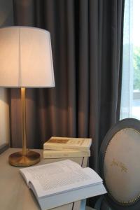 a lamp on top of a desk next to a bookshelf at Hotel José Régio in Portalegre