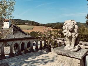 statua di leone in pietra seduta sopra un balcone di Der Turm Leiben Apartments a Leiben