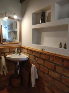 uma casa de banho com um lavatório e um espelho em Casita roja em Cercedilla