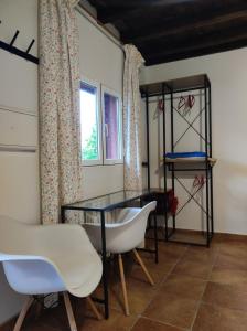 a room with a glass table and chairs and a window at Casita Roja sin cocina in Cercedilla