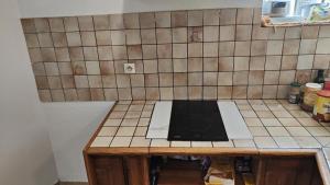 a kitchen counter with a microwave on top of it at Hôtel Les 4 Chênes in Pontault-Combault