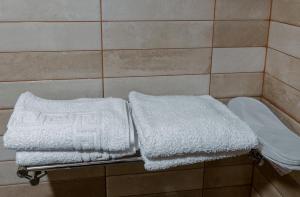 due asciugamani bianchi su una mensola nella doccia di Unique Boutique Hotel Near Batumi a Batumi