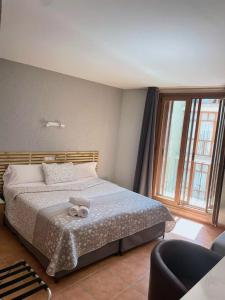 a bedroom with a bed with a teddy bear on it at Hotel Acebo Plaza Mayor in Jaca
