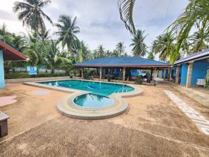 a swimming pool in front of a house at Blue Beach Bungalow in Bang Saphan Noi