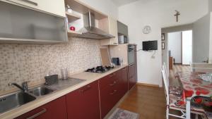 a kitchen with red cabinets and a sink at Appartamento Via Ponchielli in Perugia