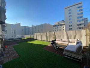 a couch sitting on a lawn in a backyard at 50m Gem - 400m Gare: garage privé, terrasse, wifi in Grenoble