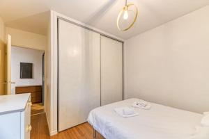 - une chambre blanche avec un lit et un placard dans l'établissement 50m Gem - 400m Gare: garage privé, terrasse, wifi, à Grenoble