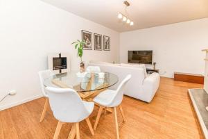 - un salon avec une table en verre et des chaises blanches dans l'établissement 50m Gem - 400m Gare: garage privé, terrasse, wifi, à Grenoble