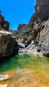 a pool of emerald green water in a canyon at the suwgra-Al-Jabal Al-Akdar in Sūkirah