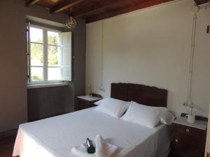 a bedroom with a bed with a towel on it at Casa de Campo Pumarada de Oirín in Foz