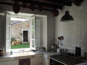 a kitchen with a sink and an open window at Casa de Campo Pumarada de Oirín in Foz