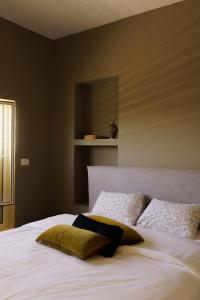 1 dormitorio con 1 cama blanca grande y 2 almohadas en סיני 48 מלון דירות בוטיק en Vered Yeriho