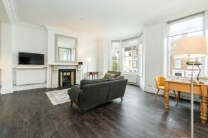 uma sala de estar com um sofá e uma mesa em Stylish 2 bedroom at Hammersmith em Londres