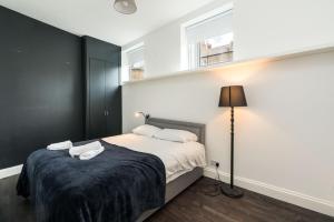 a bedroom with a bed and a lamp and a window at Stylish 2 bedroom at Hammersmith in London