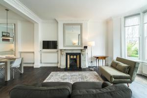 a living room with a couch and a fireplace at Stylish 2 bedroom at Hammersmith in London +11 photos