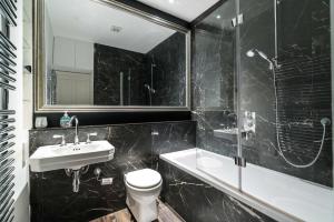 a bathroom with a sink and a toilet and a shower at Stylish 2 bedroom at Hammersmith in London