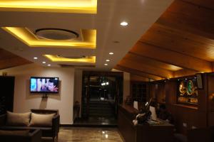 a lobby with a couch and a tv on the ceiling at Phuntsho Khangsar Hotel in Thimphu
