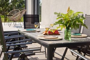 een houten tafel met twee glazen wijn bij Wingris - dom wczasowy nad Jeziorem Wigry in Bryzgiel