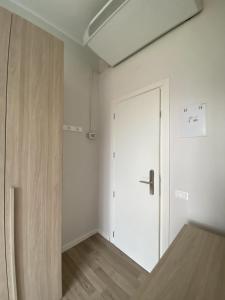 ein leeres Zimmer mit einer weißen Tür und einem Holzboden in der Unterkunft Albergo Lodrino in Villa