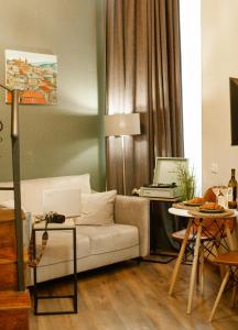 Luxury inn في تبليسي: غرفة معيشة مع أريكة وطاولة مع الكمبيوتر المحمول