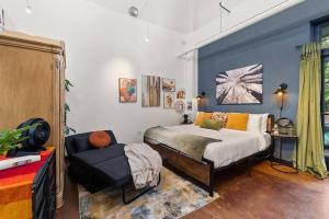 ein Schlafzimmer mit einem Bett und einem Stuhl darin in der Unterkunft Santa Fe Baca Railyard Loft! in Santa Fe