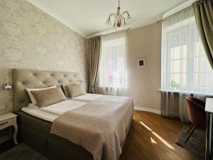 Un dormitorio con una cama grande y dos ventanas. en Very Vilnius Stikliu street, en Vilna