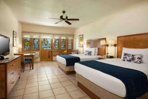 a hotel room with two beds and a flat screen tv at Copamarina Beach Resort & Spa in Guanica