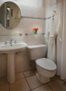a bathroom with a toilet and a sink and a mirror at Copamarina Beach Resort & Spa in Guanica