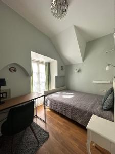 a bedroom with a bed and a desk and a chandelier at Very Vilnius Stikliu street in Vilnius