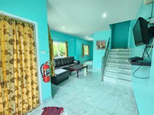 sala de estar con paredes azules y sofá en Blue Beach Bungalow, en Bang Saphan Noi