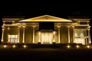 a large white building with lights at night at The Grand Monarch Hotel, Ujjain in Ujjain