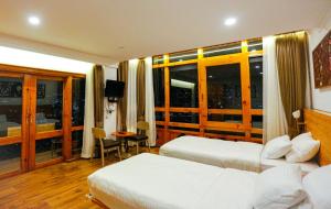 um quarto de hotel com duas camas e uma grande janela em Phuntsho Khangsar Hotel em Thimphu