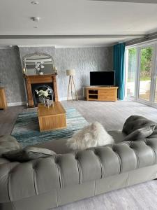 sala de estar con sofá y chimenea en Cameron Coach House Modern Property in Murrayfield Edinburgh, en Edimburgo