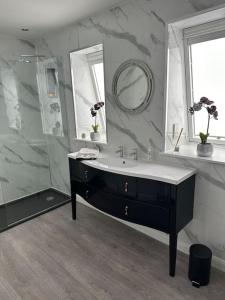 W łazience znajduje się umywalka i prysznic. w obiekcie Cameron Coach House Modern Property in Murrayfield Edinburgh w Edynburgu
