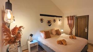 a bedroom with a bed with brown pillows on it at Casa do Palmeiral - Hoom B&B in Montes de Cima +25 photos
