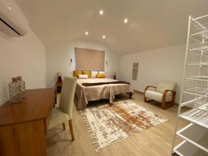 Schlafzimmer mit einem Bett, einem Schreibtisch und einem Stuhl in der Unterkunft Penha D'Águia Villa by LovelyStay in Porto da Cruz