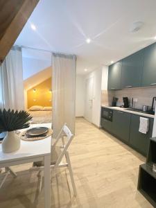 uma cozinha com uma mesa branca e uma cadeira branca em Sacré appartement/Jardin/Parking/Wifi em Rodez
