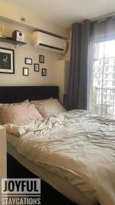 ein unverbautes Bett in einem Schlafzimmer mit einem Fenster in der Unterkunft Condo with resort-like living, everyday in Lapu Lapu City