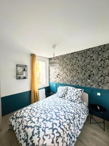 - une chambre avec un lit et un mur en pierre dans l'établissement Sacré appartement/Jardin/Parking/Wifi, à Rodez