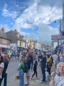 una multitud de personas caminando por una calle en Whitstable contemporary cosy home with parking, en Kent