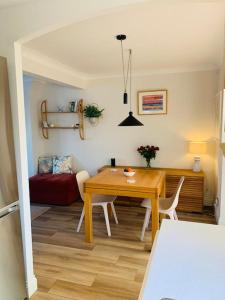 a dining room with a table and a red couch at Whitstable contemporary cosy home with parking in Kent